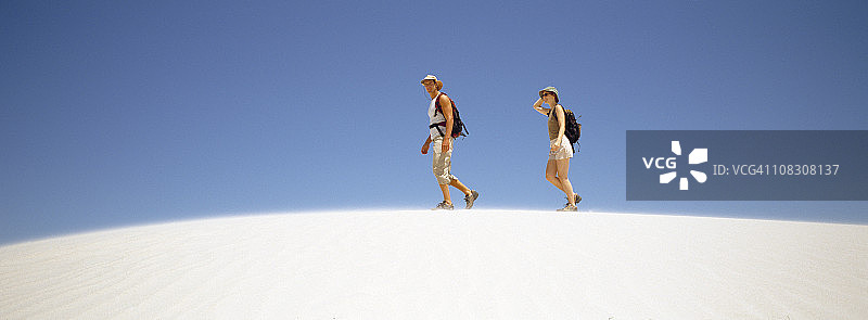 在白色沙漠中散步的年轻夫妇图片素材