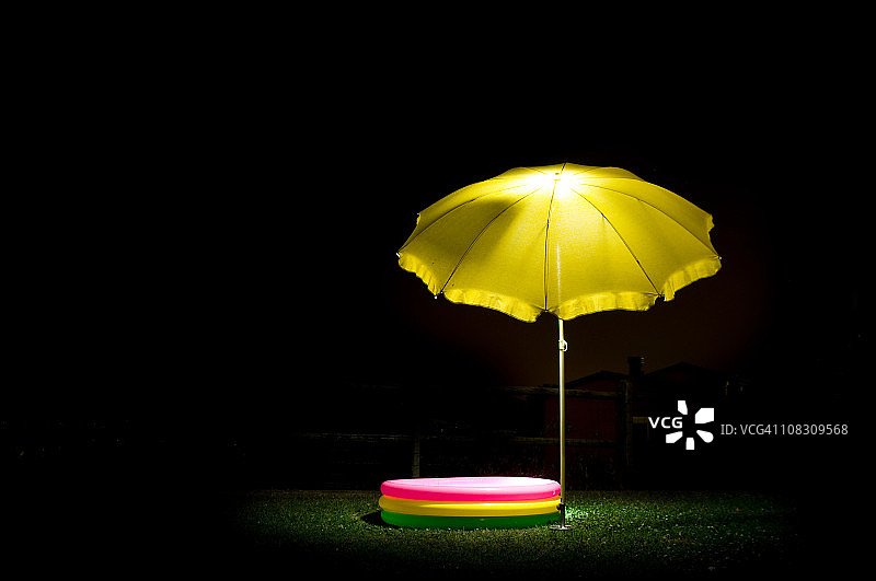 夜晚的黄色阳伞和儿童泳池图片素材