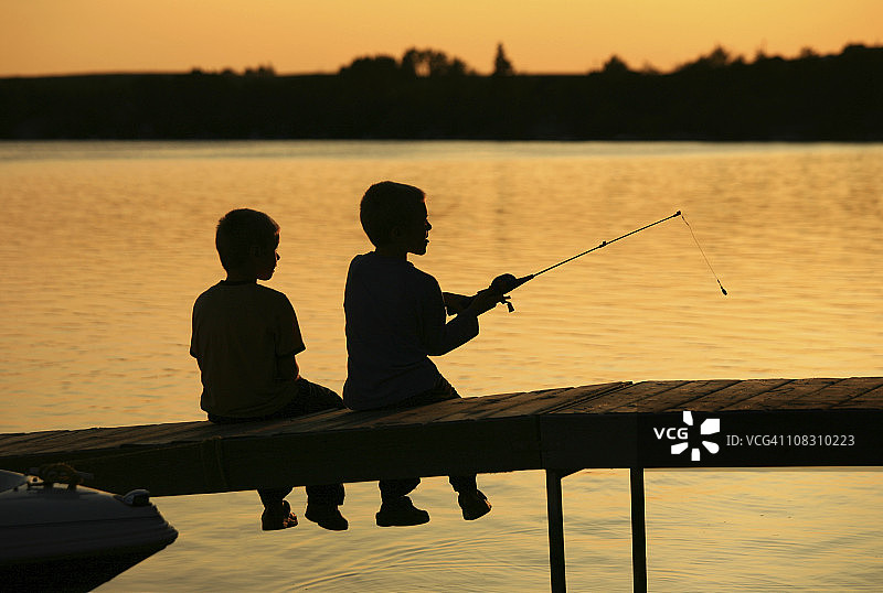 两个男孩在码头钓鱼的剪影图片素材