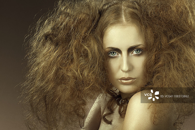 看着镜头，做蓬松发型的女人图片素材