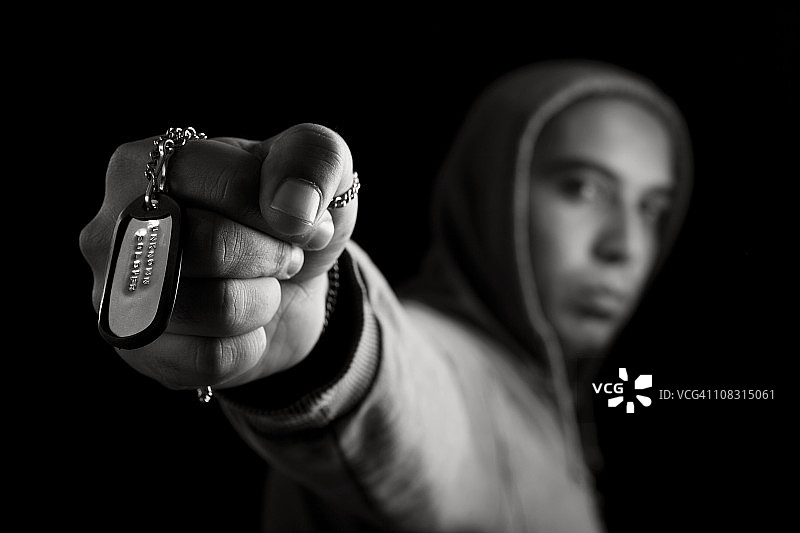 男人展示刻有“无名战士”字样的狗牌图片素材