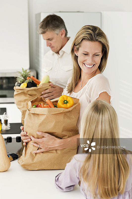 一家人笑着整理食品杂货图片素材