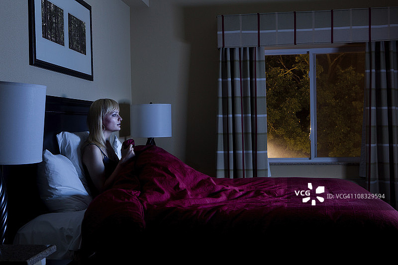深夜在床上看电视的女人图片素材