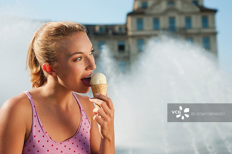 德国慕尼黑卡尔广场：年轻女子吃冰淇淋图片素材