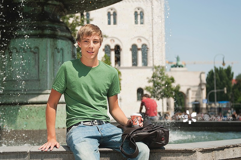 德国慕尼黑卡尔广场一位坐着远眺的年轻人图片素材