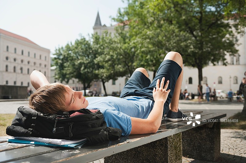 德国慕尼黑卡尔广场大学里长凳上休息的年轻男人图片素材
