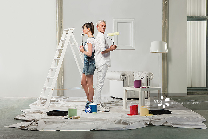 年轻夫妇用油漆装饰房间图片素材
