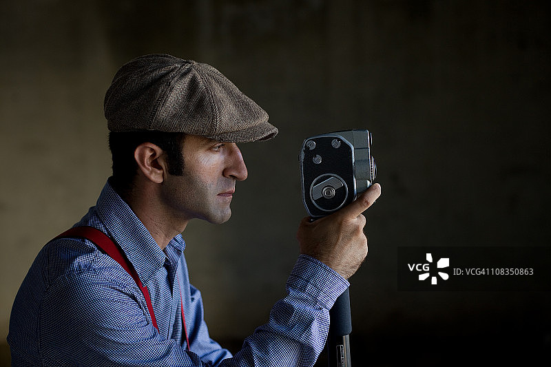 身着复古服装手持摄像机的短片导演图片素材