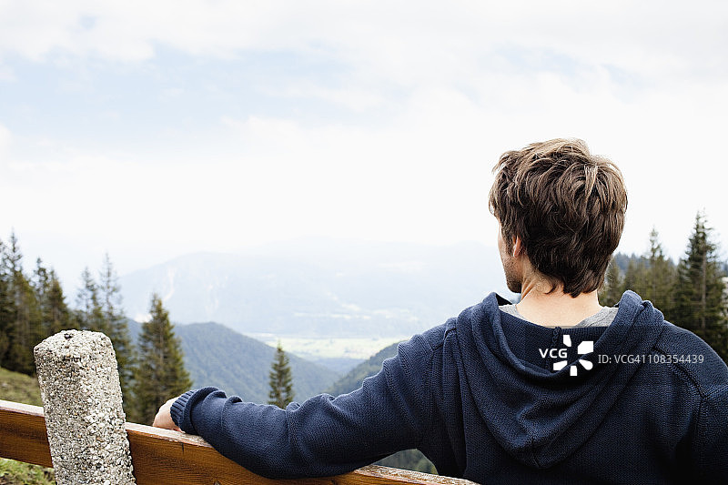 男子坐在长椅上欣赏风景图片素材
