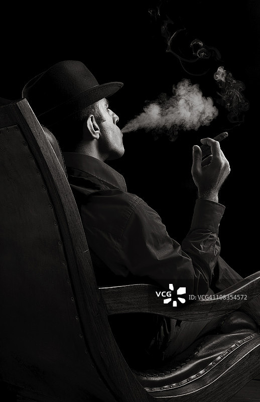 坐在扶手椅上抽雪茄的男子肖像图片素材