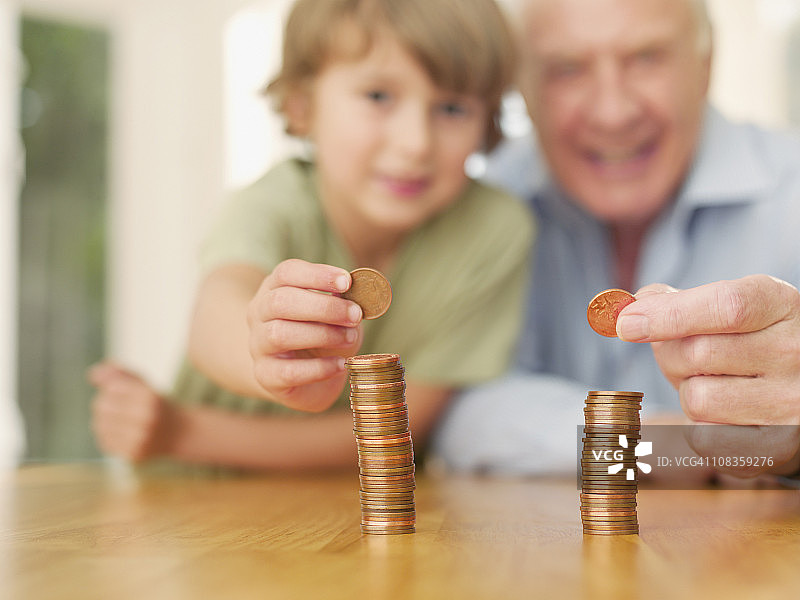 爷爷和孙子堆叠硬币图片素材