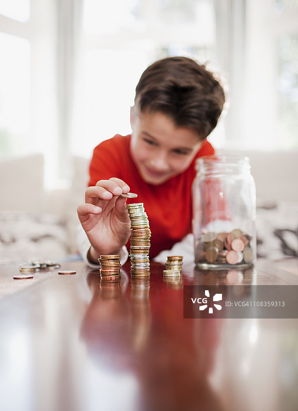 男孩堆叠硬币图片素材