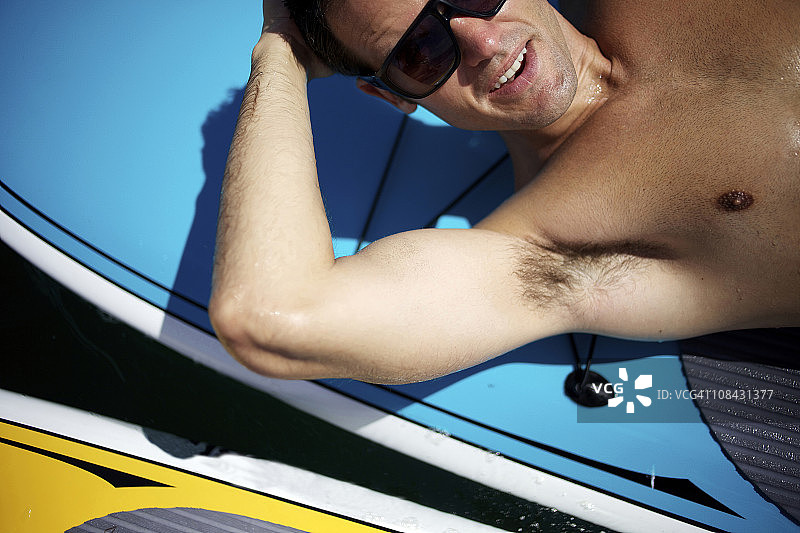 男人躺在桨板上休息图片素材