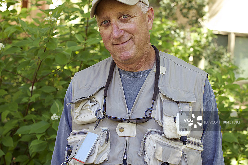 站在树叶旁的渔民的肖像图片素材