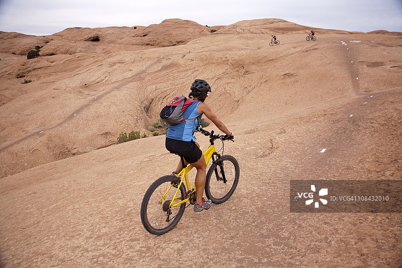 女人在犹他州摩押的斯里克岩石路线上骑山地自行车图片素材