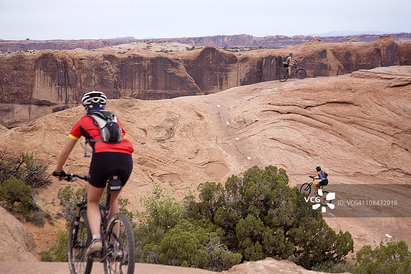 女人在犹他州摩押的斯里克岩石路线上骑山地自行车图片素材