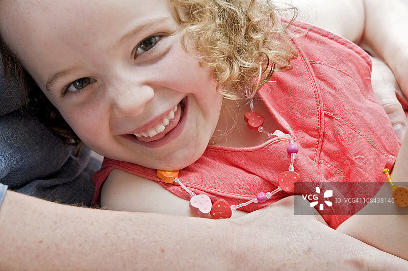 在妈妈怀里微笑的女孩图片素材