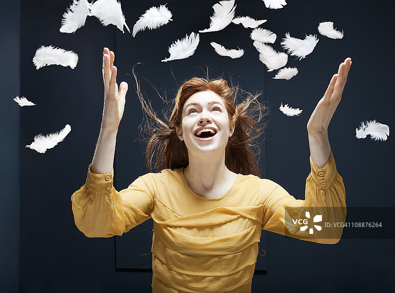 女人在风中抛洒羽毛图片素材