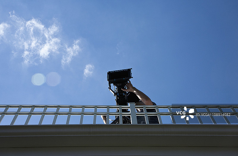摄影师在人行天桥上拍摄，低角度视角图片素材