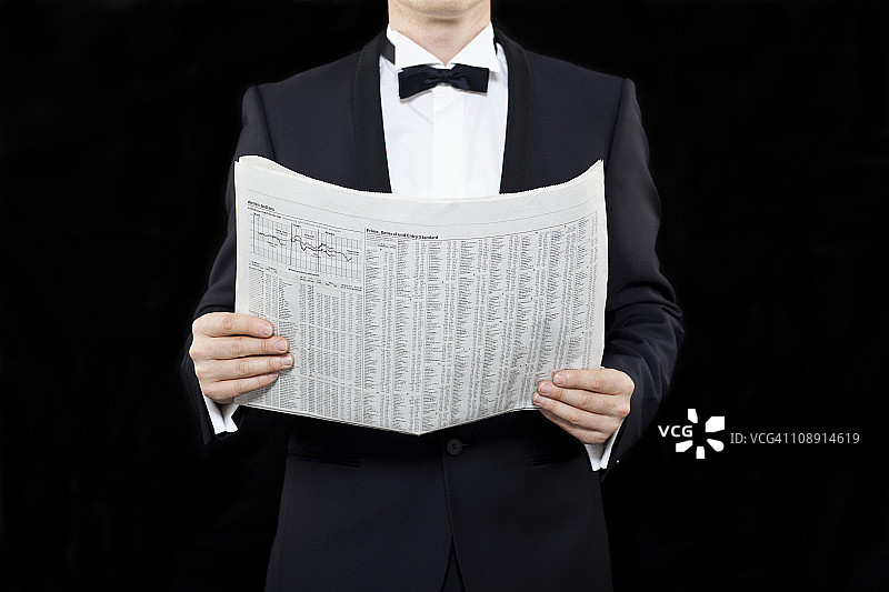 拿着财经报纸的燕尾服男士（中部）图片素材