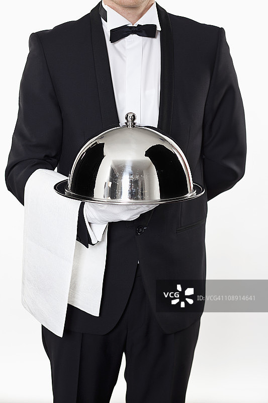 男管家端着圆顶托盘图片素材