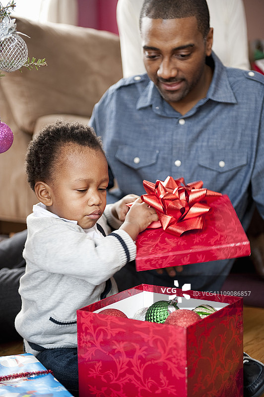 幼儿和爸爸一起打开圣诞礼物图片素材