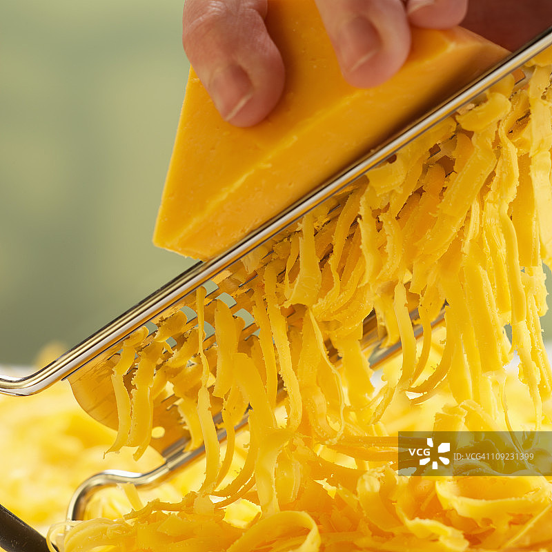 人手磨碎奶酪，特写图片素材