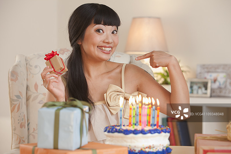 兴奋的亚洲女人拿着生日蛋糕和礼物图片素材