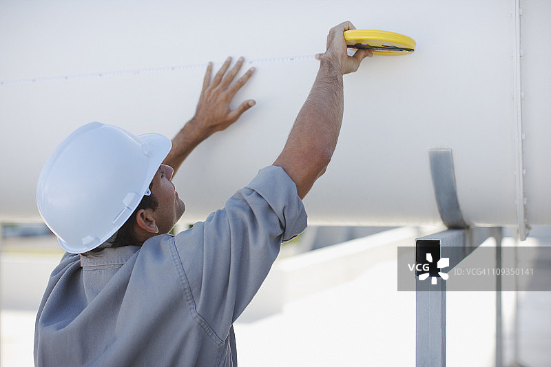 工人在户外测量大管道图片素材
