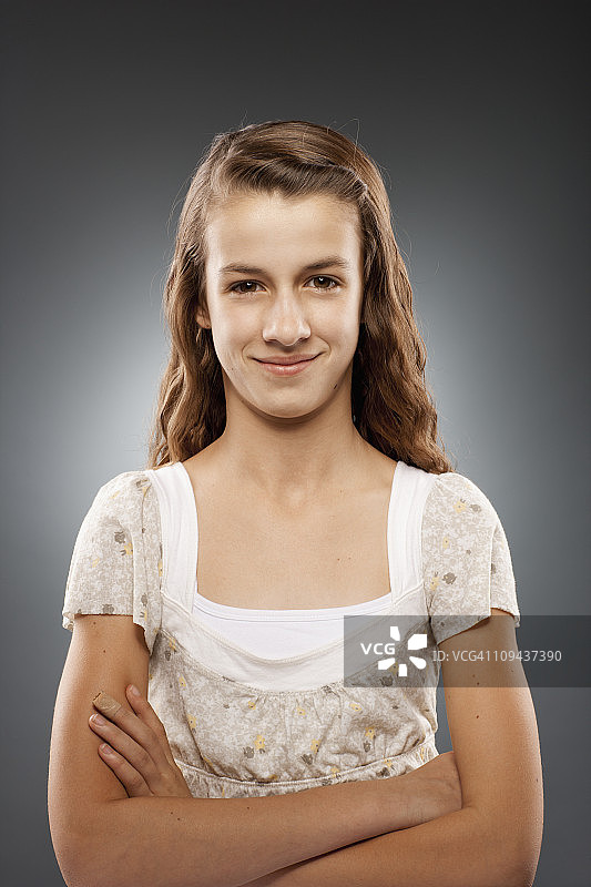 12-13岁女孩看向镜头双臂交叉影棚肖像图片素材
