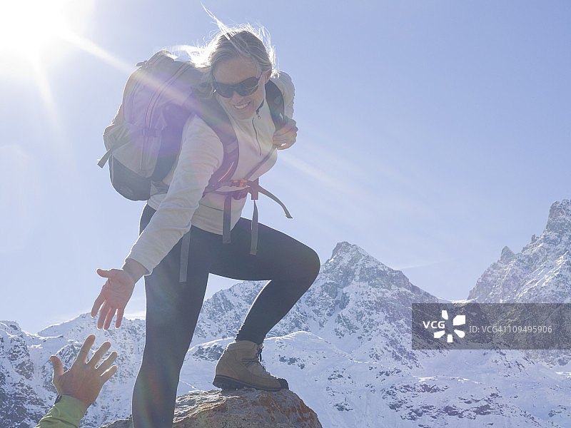 徒步女人向同伴伸出援助之手图片素材