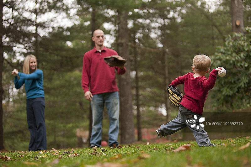男孩和父母一起打棒球，母亲用手语说“棒球”图片素材