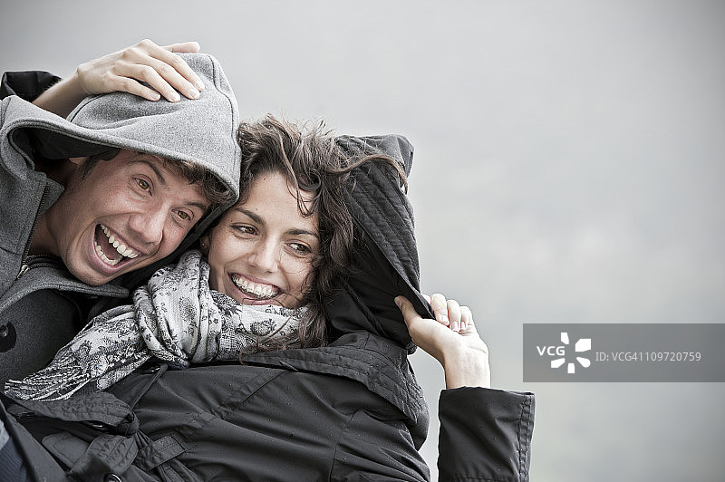 在雨天玩耍的年轻情侣图片素材