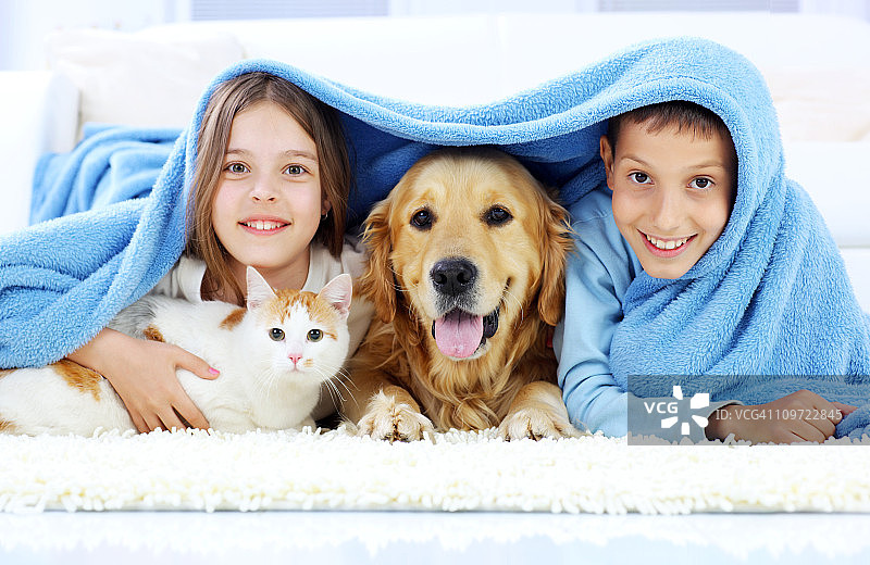 孩子们、小狗和小猫在毯子上向外看图片素材