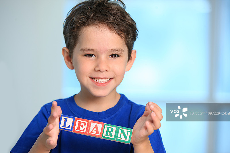 微笑的学龄前儿童拿着积木图片素材