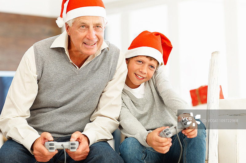 快乐的老年男人和孙子一起玩电子游戏图片素材
