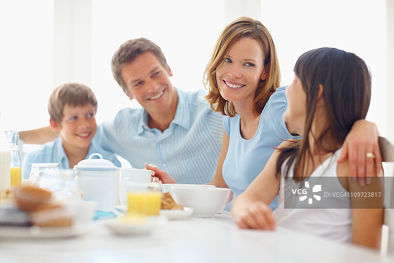 一家四口在餐桌旁享用早餐图片素材