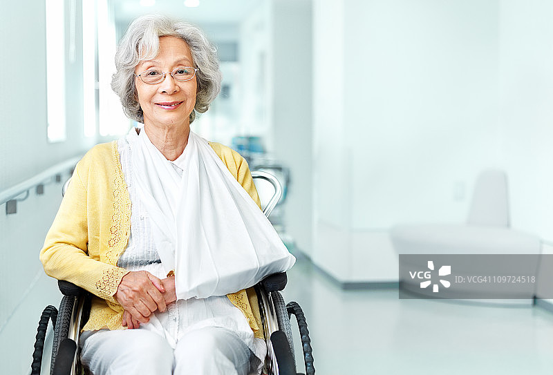 坐在轮椅上、手臂骨折的老年妇女图片素材