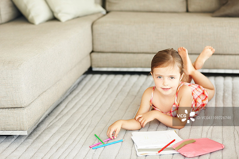 小女孩在地板上涂色图片素材