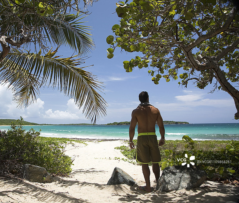 男人看着热带海滩的景色图片素材