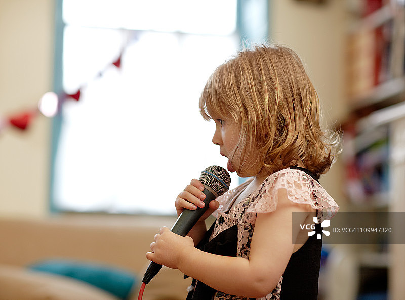 小女孩舔麦克风图片素材