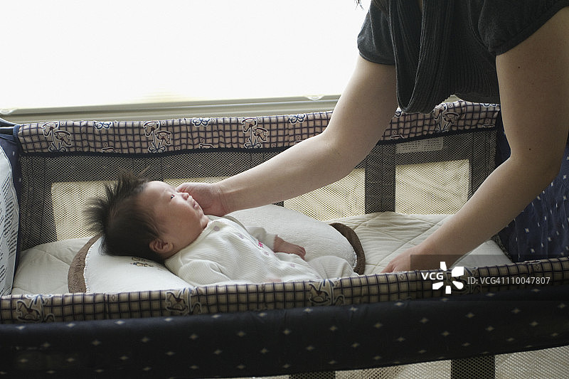 中国母亲和新生女儿在婴儿床里图片素材