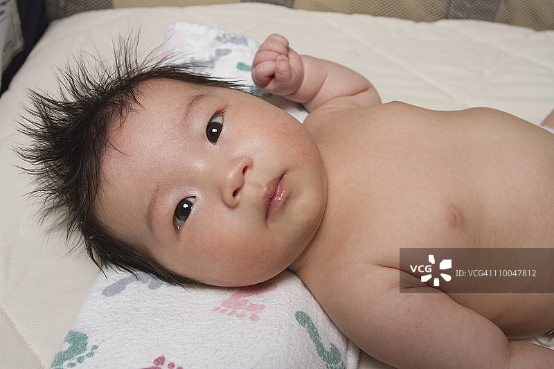 新生的中国可爱的婴儿躺在婴儿床上图片素材