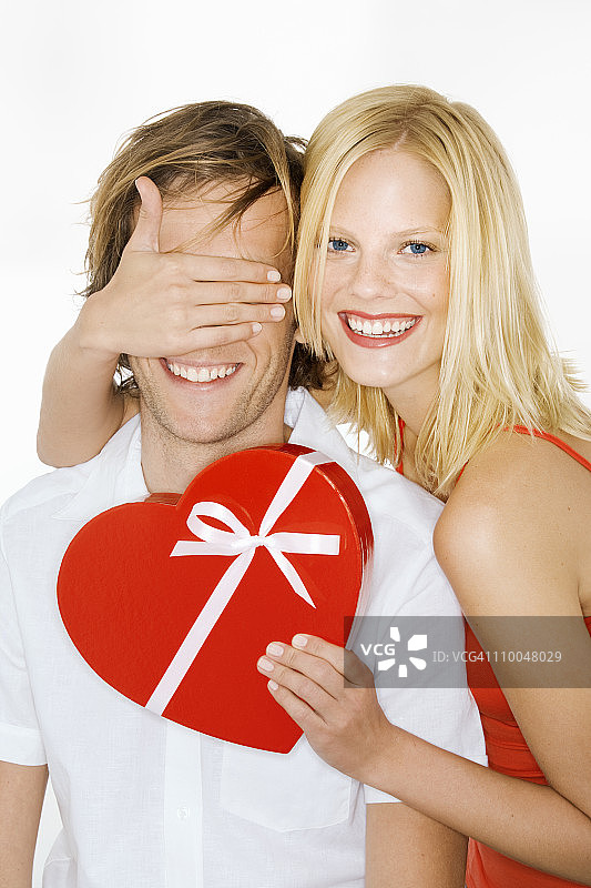 女人蒙住男人的眼睛并拿着礼物图片素材