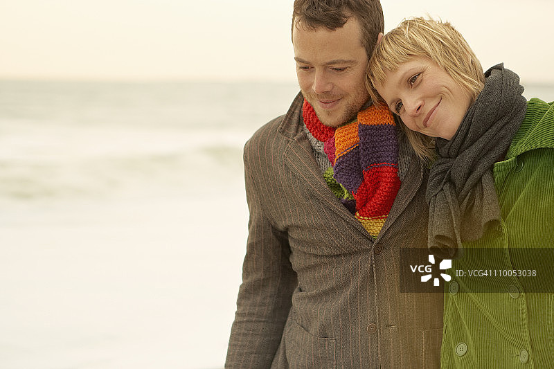 情侣在海滩上行走和拥抱图片素材