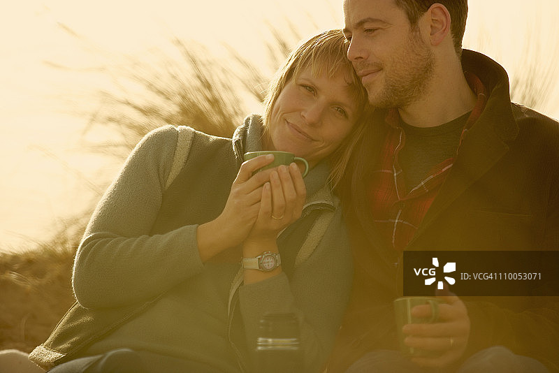 户外依偎着喝咖啡的情侣图片素材