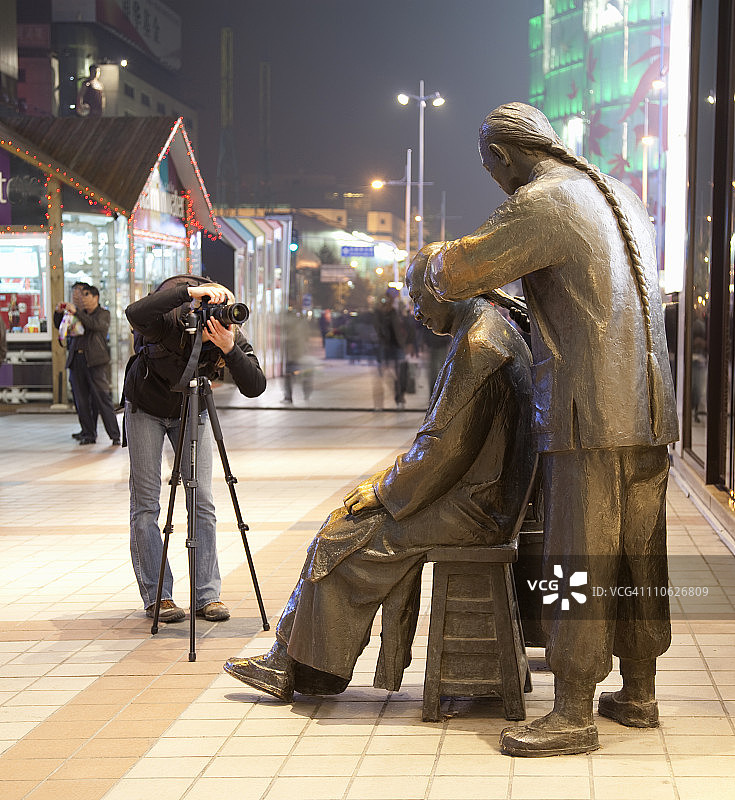 女人拍摄青铜公共艺术品图片素材