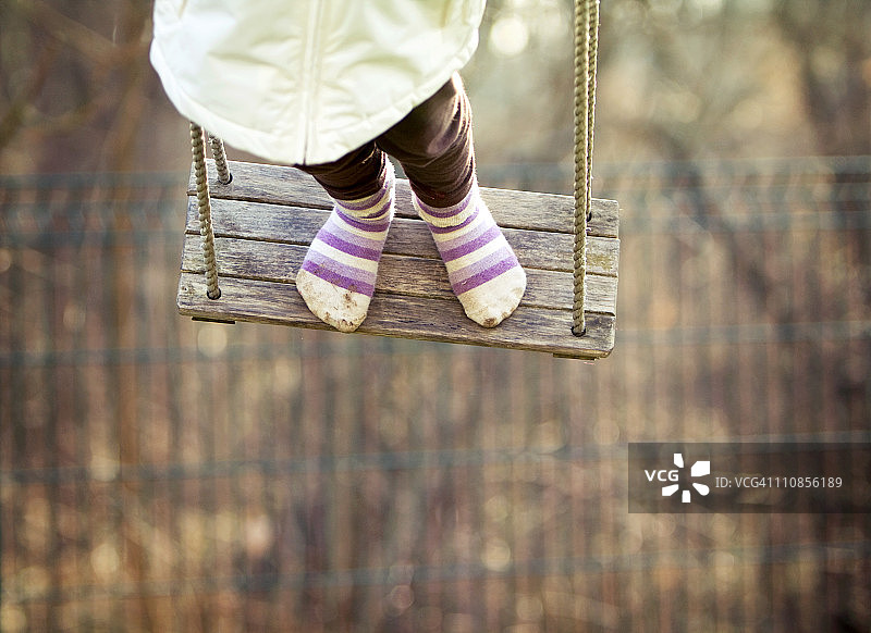 小女孩站在木制秋千上图片素材