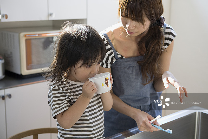 母亲看着儿子漱口图片素材