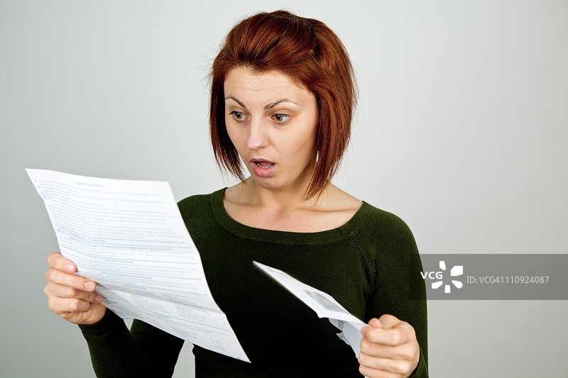 张大嘴巴的震惊女人收到信用卡账单图片素材